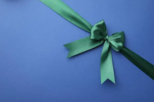 Green Satin Ribbon Bow Blue Background Top View Space Text Royalty Free Stock Photos