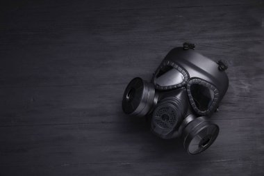 Siyah ahşap arka planda bir gaz maskesi, üst manzara. Metin için boşluk