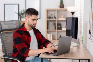 Genç programcı ofiste dizüstü bilgisayar ile çalışma
