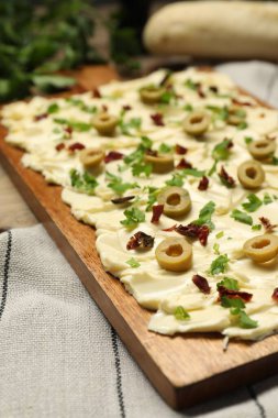 Taze tereyağı, dilimlenmiş zeytin, güneşte kurutulmuş domates ve maydanoz, yakın plan.