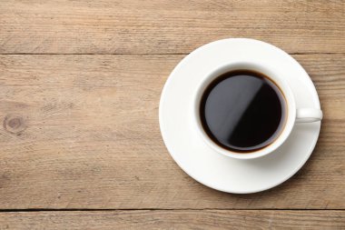 Ahşap masanın üzerinde bir fincan aromatik kahve, üst manzara. Metin için boşluk
