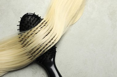 Sarı saç telli şık fırça, gri masa, üst manzara. Metin için boşluk