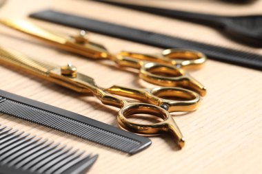 Kuaför aletleri. Farklı makas ve taraklar ahşap masada, yakın plan.