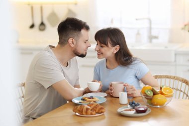 Mutlu çift evde lezzetli bir kahvaltı yapıyor.