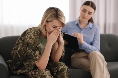 Ofiste asker bir kadınla çalışan psikoterapist.