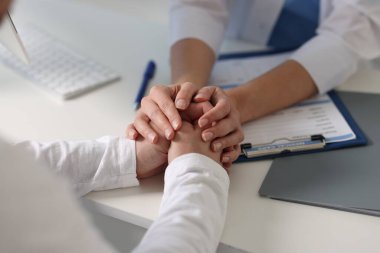 Hastanedeki beyaz masada hastayla çalışan profesyonel bir doktor.