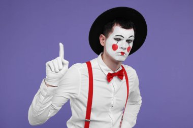 Mor arka planda jest yapan komik pandomimci