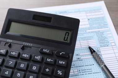 Vergi muhasebesi. Hesap makinesi, belge ve kalem masanın üzerinde, yakın plan