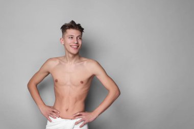 Yüzünde açık gri arka planda nemlendirici krem olan yakışıklı bir adam. Metin için boşluk