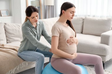 Doula evde hamile bir kadınla çalışıyor. Çocuk doğumu hazırlığı