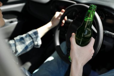 Bira şişesi sürücüsü arabası olan bir adam, yakın plan. İçkili araba kullanma.