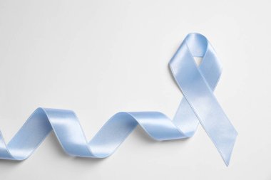 International Psoriasis Day. Light blue ribbon as symbol of support on white background, top view clipart