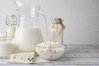 Beyaz ahşap masada farklı taze süt ürünleri. Metin için boşluk