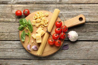 Farklı türde makarna ve ürünleri olan tahta masa, düz.