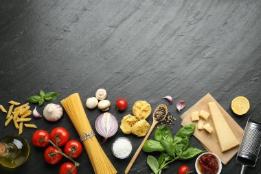 Farklı türde makarna, baharat, jartiyer ve ürünler koyu dokulu masa, düz yatak. Metin için boşluk