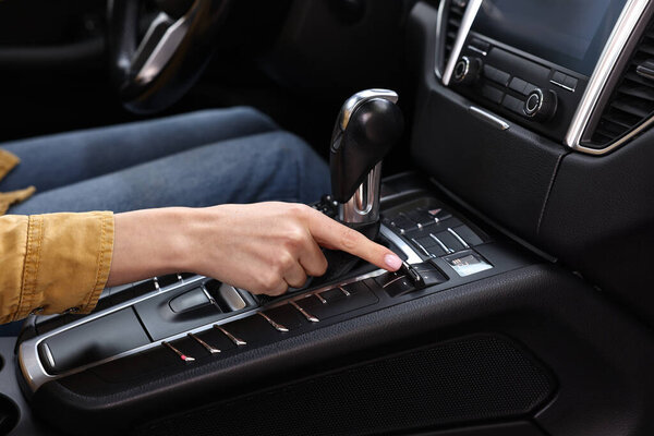 Woman using gear stick while driving her car, closeup