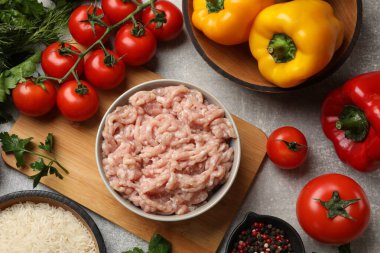 Doldurulmuş biber yapıyorum. Ground meat ve diğer malzemeler gri masada, düz yatıyordu.