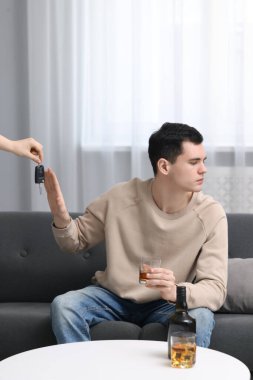 Sarhoş adam araba kullanmayı reddederken kadın ona anahtar öneriyor, kapat. İçkili araba kullanma.