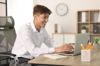 Ofisteki ahşap masada Webinar izleyen adam.