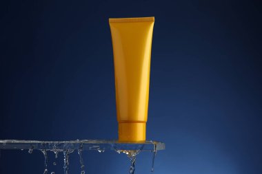 Cam üzerinde nemlendirici krem ve mavi arka planda su damlaları. Metin için boşluk