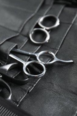 Kuaför aletleri. Profesyonel makas ve tarak deri düzenleyicide, yakın plan.