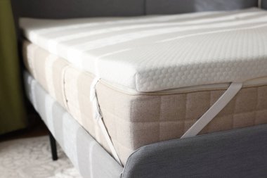 Beyaz hatıra köpük yatak üstü kapalı gri yatak, yakın plan.