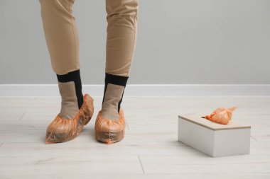 Parlak ayakkabı örtüleri giyen bir kadın, kapalı bir yerde, yakın plan.