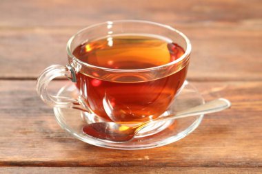 Tahta masada bir bardak çay ve kaşık.