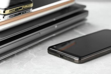 Gri taş masadaki elektronik cihazların yığını, yakın plan