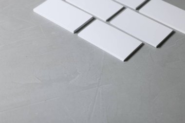 Açık gri desenli masada boş kartvizitler, yakın plan. Tasarım için model