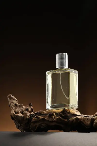 stock image Luxury men`s perfume in bottle on grey table against brown background