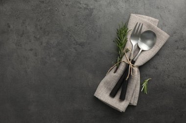 Siyah masa üzerinde çatal bıçak ve peçete bulunan şık bir dekor. Metin için boşluk