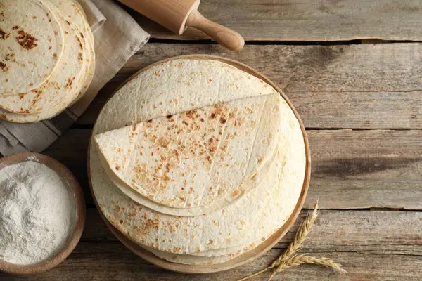 Lezzetli ev yapımı tortilla, un, oklavalı iğne ve çiviler tahta masada, düz yerde. Metin için boşluk