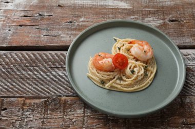 Tahta masadaki lezzetli spagetti, domates, karides ve peynirden yapılmış kalp. Metin için boşluk