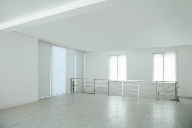 Pencereleri ve parmaklıkları olan büyük boş bir salon.