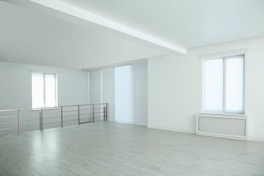 Pencereleri ve parmaklıkları olan büyük boş bir salon.