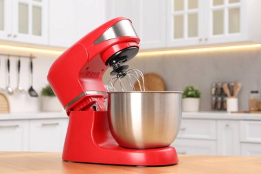 Mutfaktaki ahşap masada modern kırmızı stand mikseri.