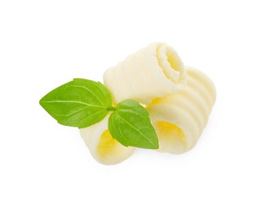 Lezzetli tereyağı bukleleri ve fesleğen yaprakları beyaz üzerine izole edilmiş.
