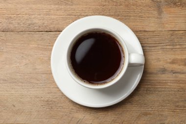 Ahşap masanın üzerinde bir fincan aromatik kahve, üst manzara. Metin için boşluk