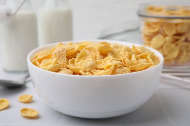 Beyaz masada kasede gevrek mısır gevrekleri, yakın plan. Kahvaltı gevreği.