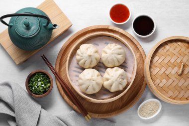 Lezzetli bao çörekleri (baozi), yemek çubukları, soslar, baharatlar ve tencere dibin kara seninki benden kara.