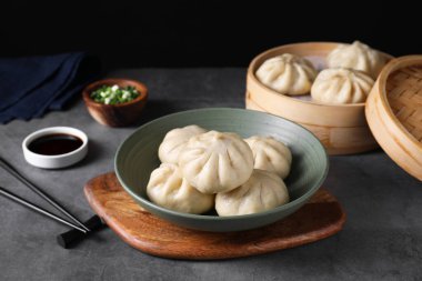 Lezzetli çörekler (baozi) gri masada, yakın plan.