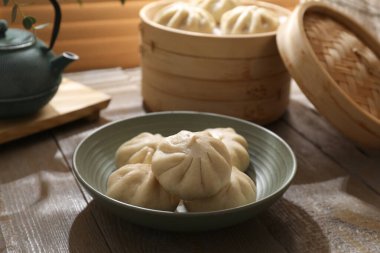Lezzetli bao çörekleri (baozi) ahşap masada, yakın plan