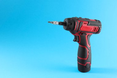 Açık mavi arka planda modern elektrikli tornavida. Metin için boşluk
