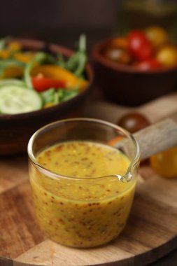 Ahşap masa üzerinde lezzetli sirke sosu (Vinaigrette), yakın plan.