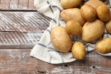 Tahta masada çiğ patates ve peçete, üst manzara. Metin için boşluk
