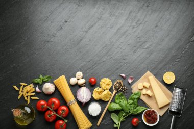 Farklı türde makarna, baharat, jartiyer ve ürünler koyu dokulu masa, düz yatak. Metin için boşluk