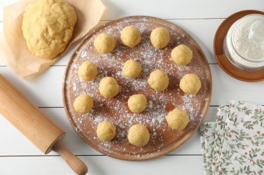 Kısa hamurlu börek. Çiğ hamur topları, un ve merdane beyaz ahşap masa, düz yatıyordu