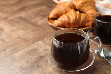 Cam bardakta sıcak kahve, ahşap masada, yakın plan. Metin için boşluk