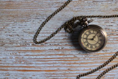 Eski ahşap masa üzerinde zincirli cep saati, üst manzara. Metin için boşluk